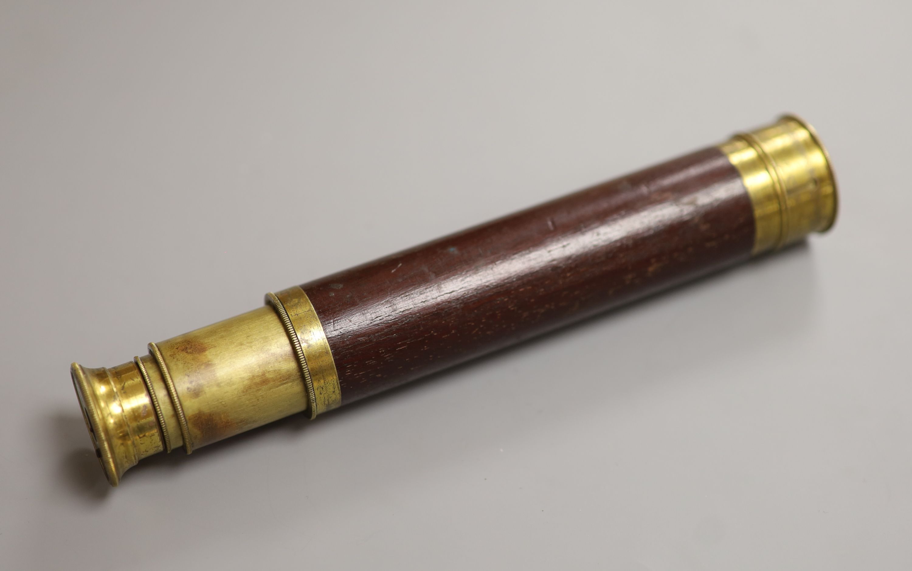 An early 20th century brass and mahogany three drawer telescope, overall length 40.5cm extended